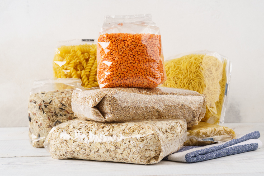 various-raw-groats-cereal-grains-pasta-transparent-plastic-bags-kitchen-table-ingredients-cooking
